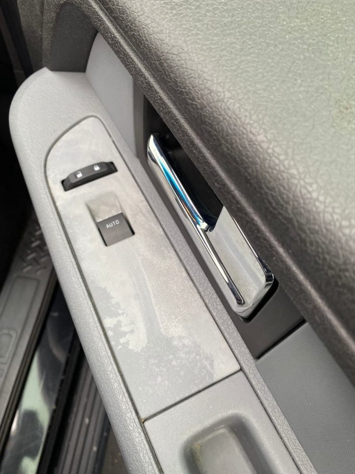 Before photo of a car door panel that is damaged.