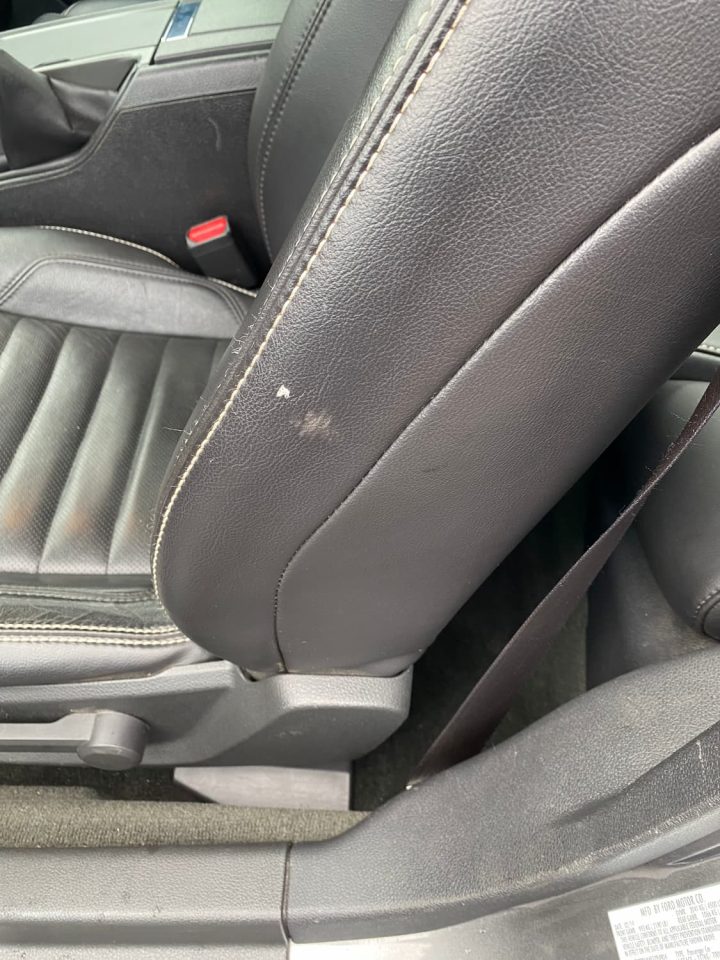 Before photo of the side of a car seat with a gouge out of the side of the vinyl on the seat.